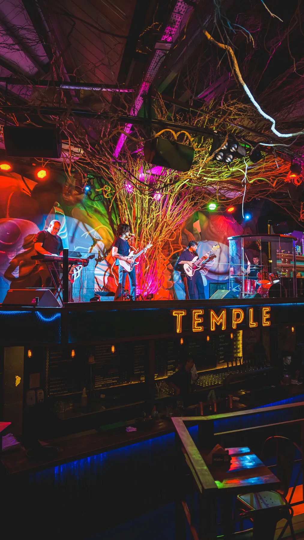 The Fandom Band en el escenario de Club Temple, con luces de colores y el cartel TEMPLE