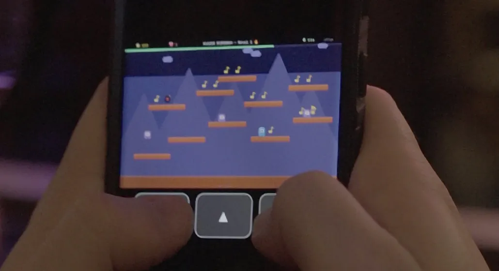 Un celular mostrando el videojuego de plataformas hecho por la banda